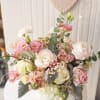 Pastel bouquet of pink and white flowers in a white container