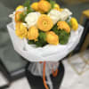 Bouquet of yellow and white ranunculus wrapped in white paper