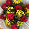 Bouquet of red roses and small yellow daisies wrapped in pale paper
