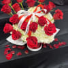 Red roses arranged over white hydrangeas with a ribbon bow