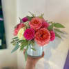 Pink and coral roses with magenta blooms in a silver vase