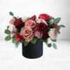 Mixed rose arrangement in a black cylindrical vase