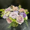 Lavender and blush roses with purple daisies in a glass vase