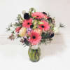 Pink gerbera and peach roses in a glass vase