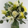 White roses and lilies in a glass vase with yellow filler flowers