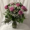 Bouquet of lavender roses and white baby's breath in a glass vase