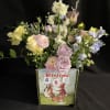 Pastel flower arrangement in a book-shaped container with bunny artwork