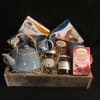 Gift basket with tea, biscotti, honey, jam, and a blue teapot