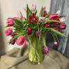 Pink and red tulips in a clear glass vase