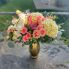 Pink roses and white orchids in a gold vase