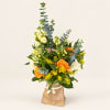 Mixed bouquet in a paper bag with orange and yellow flowers