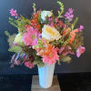 Pink and white mixed flower arrangement in a tall white vase