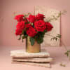 12 red roses arranged in a golden vase