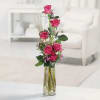 Tall pink rose arrangement in a clear glass vase