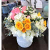 A dainty, soft and colorful arrangement of hydrangea and tiny spray roses.