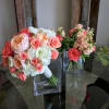 Bouquets of pink and white roses in clear glass vases