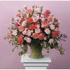 Large arrangement of pink and coral carnations in a green vase