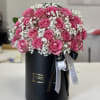Pink roses arranged in a black hatbox with white baby's breath