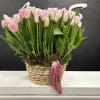 Basket of pink and white tulips with a pink ribbon