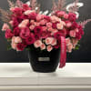 Large bouquet of pink and red roses in a black vase