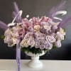 Lavender and blush rose arrangement in a white pedestal vase