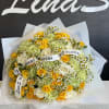 Bouquet of yellow, white, and pale green roses with small daisies