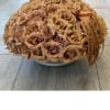 Round bouquet of tan roses with an orange ribbon