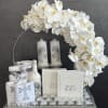 White orchid arrangement with candles, Holy Bibles, and religious keepsakes