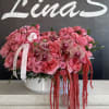 Pink rose arrangement with orchids in a white bowl vase