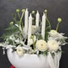 White floral arrangement with candles in a bowl-shaped vase
