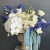 Soft white roses and airy blue delphinium, whispering calm, grace, and refined