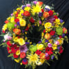 The "Guardian Angel" arrangement blends multicolor roses, mums, hypericums, mini roses, solidago