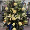 The "Peaceful Passage" arrangement blends white roses, alstroemerias, carnations, and hypericum with