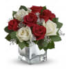Red and white roses in a clear square vase