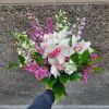 Lavender Lace Bouquet: Featuring white cymbidium orchids, hydrangeas, lilac, and stock, this