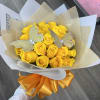 Bouquet of yellow roses wrapped in tan and white paper with silver butterfly picks