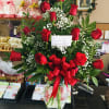 Red rose in a vase with baby breath and filler green.