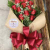 1 DOZEN RED ROSES WRAPPED IN PAPER LAYING DOWN