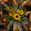 Tropical bouquet with sunflowers, red tulips, and pink snapdragons in a glass vase
