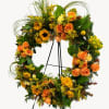 Orange and yellow floral wreath on a stand