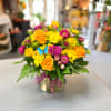 Bright mixed bouquet of yellow and orange flowers in a glass vase