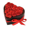 Heart-shaped box filled with red roses and tied with a red ribbon