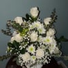 White sympaty urn, roses, babysbreath, mums and eucalyptus.