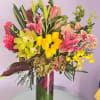 Tall mixed bouquet with lilies, orchids, and roses in a glass vase