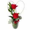 Two red roses in a glass vase with a heart-shaped wire frame