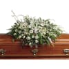 White floral casket spray with roses and lilies
