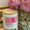Pink hydrangeas beside a white candle jar with a wooden lid.