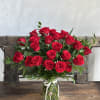 Bouquet of red roses in a clear glass vase with a white ribbon