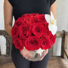 Red rose bouquet with a white orchid in a clear glass vase