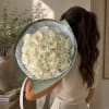 Large bouquet of cream roses wrapped in pale green paper